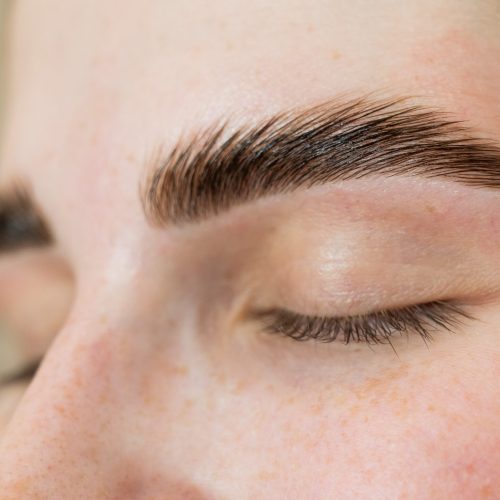 Close-up portrait of a woman after the procedure of correction and lamination of eyebrows